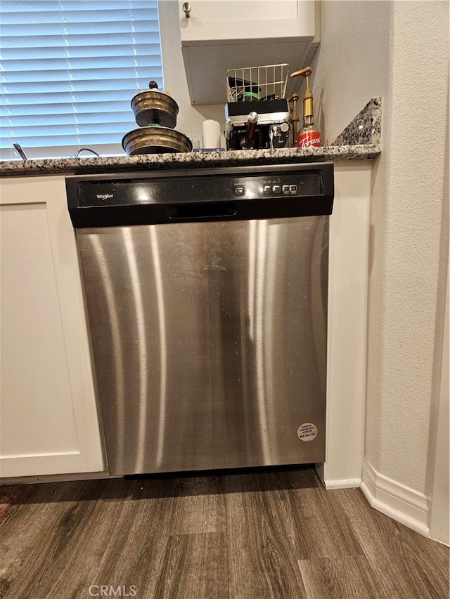 room details with dishwasher, dark stone counters, dark hardwood / wood-style floors, and white cabinets