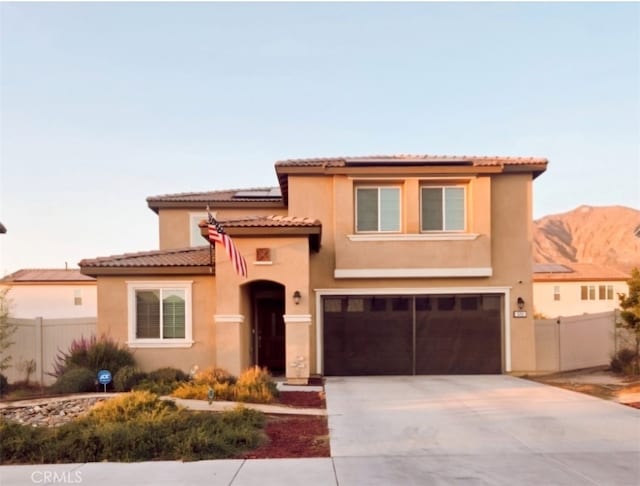 mediterranean / spanish-style home with a mountain view and a garage