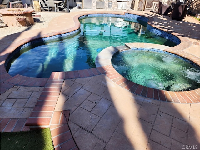 view of pool with an in ground hot tub and a patio