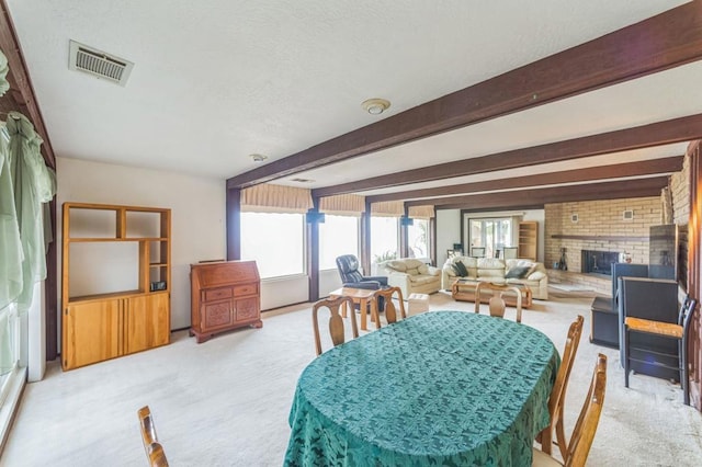 dining space featuring a fireplace, light colored carpet, and plenty of natural light