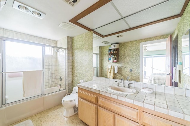 full bathroom with vanity, toilet, shower / bath combination with glass door, and plenty of natural light