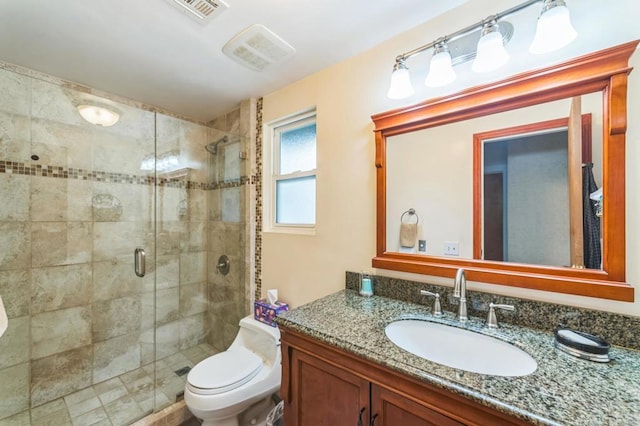 bathroom with vanity, a shower with shower door, and toilet