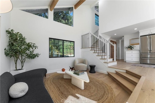 interior space with beam ceiling, high vaulted ceiling, and hardwood / wood-style flooring