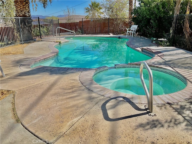 view of pool with a patio and an in ground hot tub