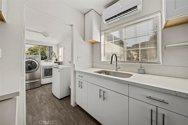 kitchen with separate washer and dryer, vaulted ceiling, white cabinets, sink, and a wall mounted air conditioner