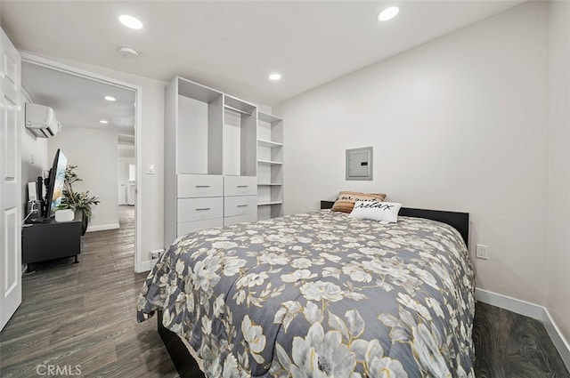 bedroom with a wall mounted AC and dark hardwood / wood-style flooring