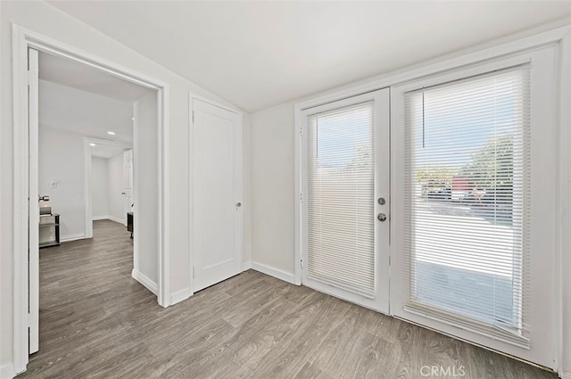 doorway featuring light hardwood / wood-style flooring and lofted ceiling