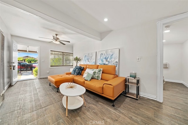 living room featuring hardwood / wood-style floors, ceiling fan, and beam ceiling