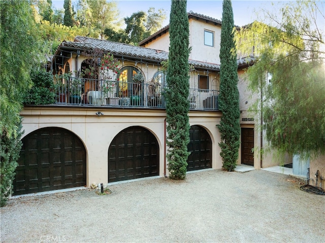 mediterranean / spanish home featuring a balcony and a garage