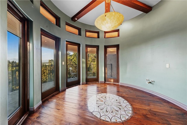 doorway to outside featuring beamed ceiling and hardwood / wood-style floors