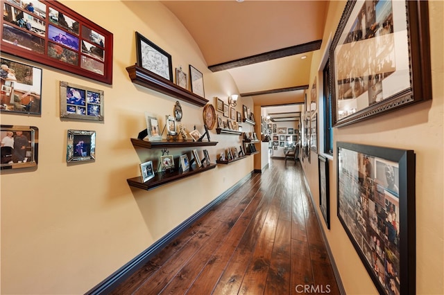 corridor featuring hardwood / wood-style flooring and vaulted ceiling