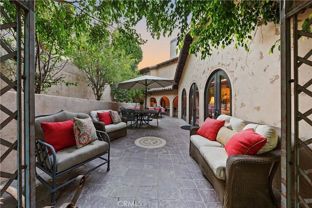 patio terrace at dusk with an outdoor living space and french doors