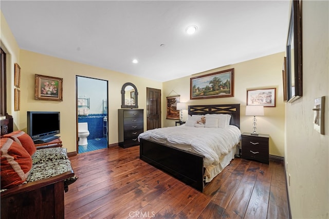 bedroom featuring ensuite bathroom and dark hardwood / wood-style flooring