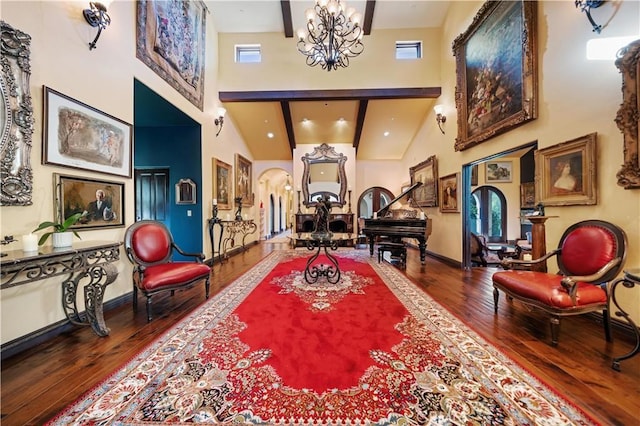 living area featuring a notable chandelier, beamed ceiling, a high ceiling, and hardwood / wood-style floors