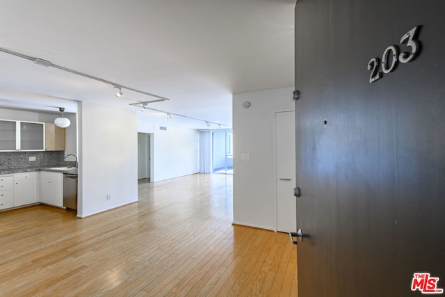 unfurnished living room featuring light wood-type flooring and sink