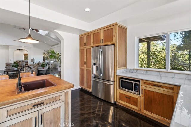 8865 San Gabriel Rd, Atascadero, CA 93422 - kitchen with stainless steel appliances, a sink, arched walkways, pendant lighting, and dark marble finish floors