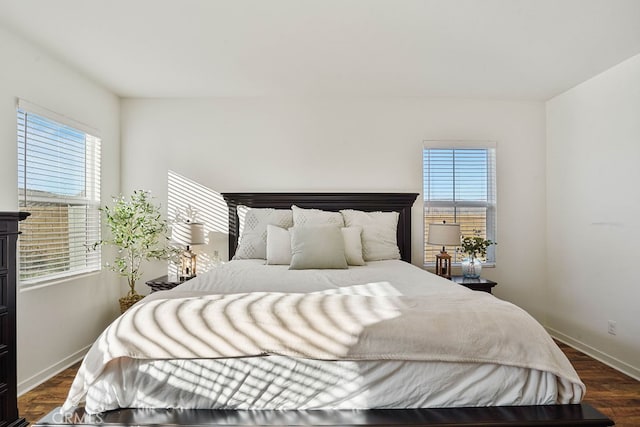 bedroom featuring multiple windows and dark hardwood / wood-style flooring