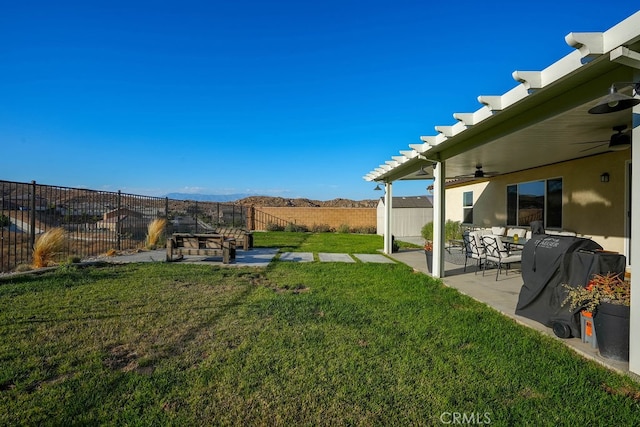 view of yard with a pergola, ceiling fan, a mountain view, and a patio area