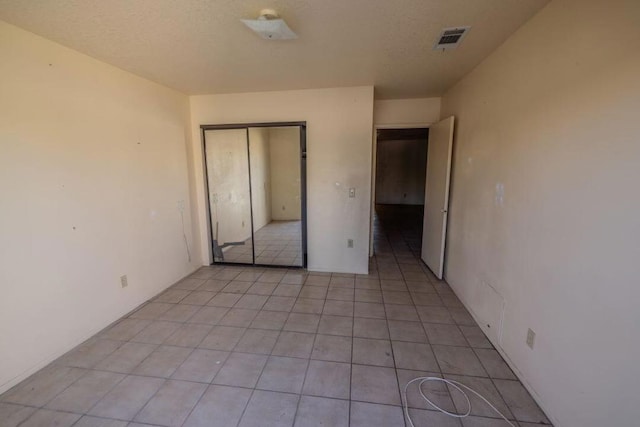 unfurnished bedroom featuring light tile patterned flooring and a closet