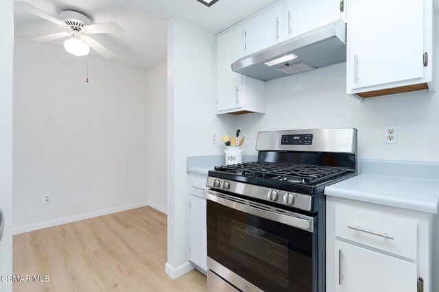 kitchen with white cabinets, light wood-type flooring, ceiling fan, and stainless steel range with gas stovetop