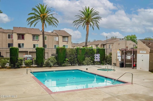 view of swimming pool featuring a community hot tub and a patio