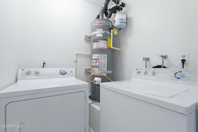 washroom with washing machine and clothes dryer, secured water heater, and a textured ceiling