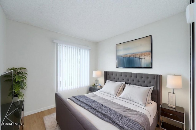 bedroom featuring light hardwood / wood-style floors and a textured ceiling