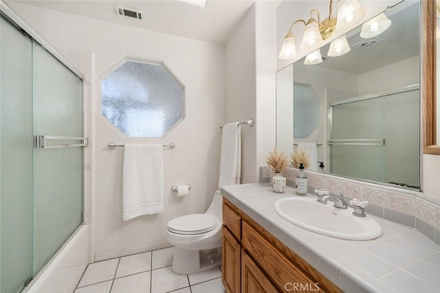 full bathroom with tile patterned floors, vanity, bath / shower combo with glass door, and toilet