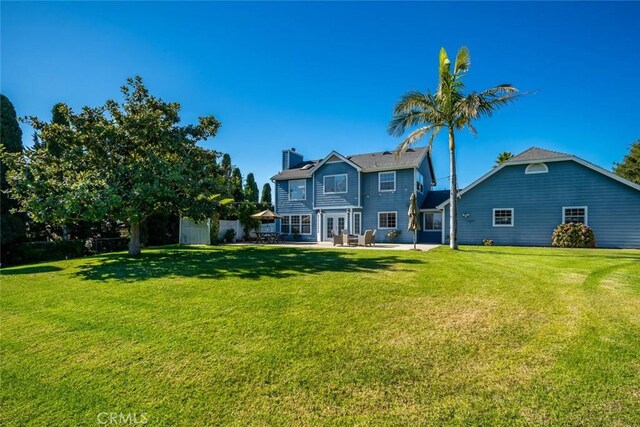 back of property with a patio and a lawn