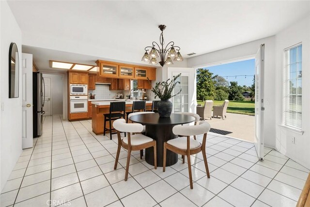 dining space featuring light tile patterned floors and a notable chandelier