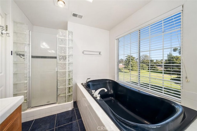 bathroom featuring tile patterned flooring, shower with separate bathtub, and vanity