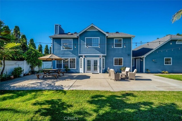 rear view of house featuring a yard, a patio, and french doors