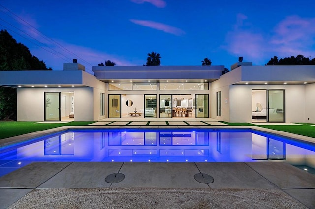 pool at dusk featuring a patio area