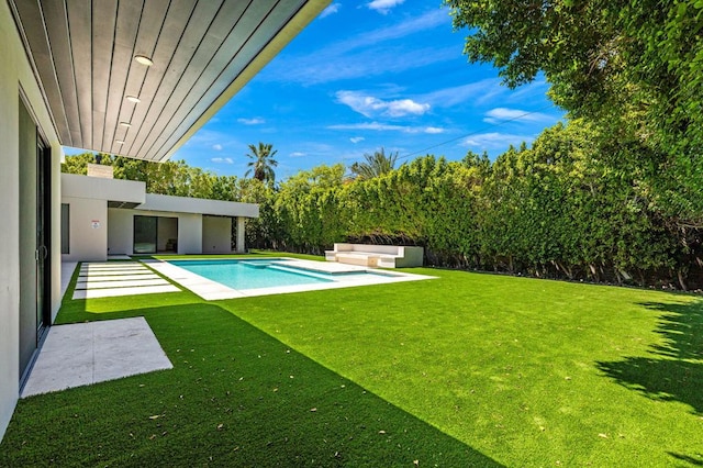 view of pool with a lawn and a patio