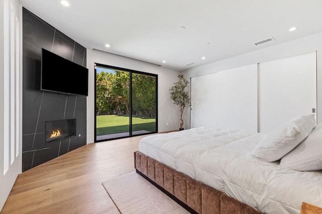 bedroom with access to exterior and light hardwood / wood-style flooring