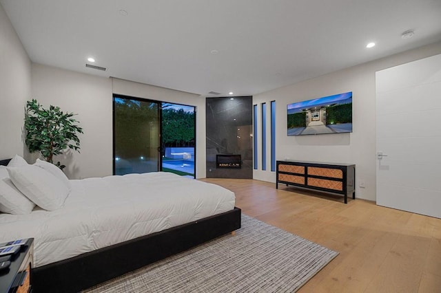 bedroom featuring access to exterior and hardwood / wood-style flooring