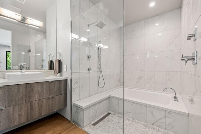 bathroom featuring vanity, plus walk in shower, and wood-type flooring