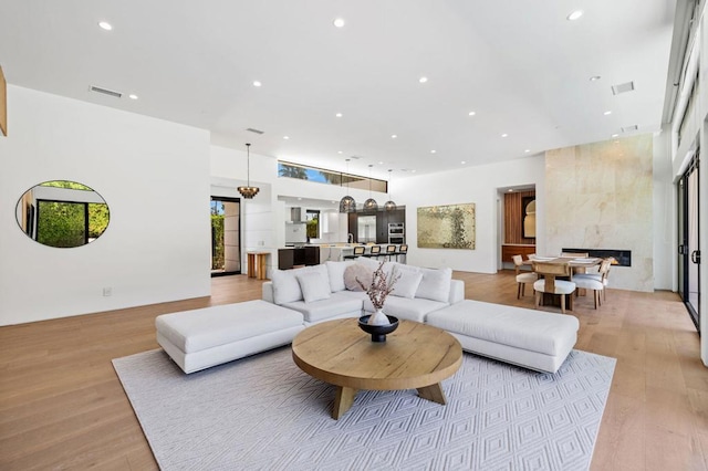 living room with light wood-type flooring and a premium fireplace