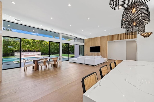 dining area featuring wooden walls and light hardwood / wood-style flooring