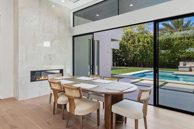 dining room with a large fireplace and light hardwood / wood-style flooring