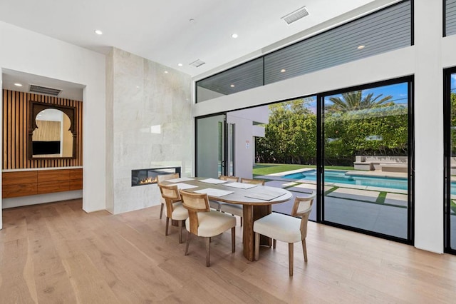 dining space featuring a premium fireplace and light hardwood / wood-style flooring