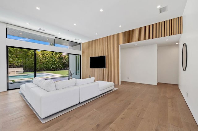 living room with wood walls and light wood-type flooring