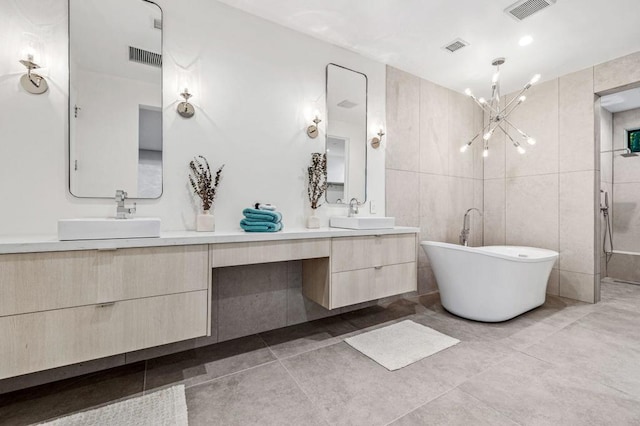 bathroom featuring a chandelier, vanity, tile patterned floors, and tile walls