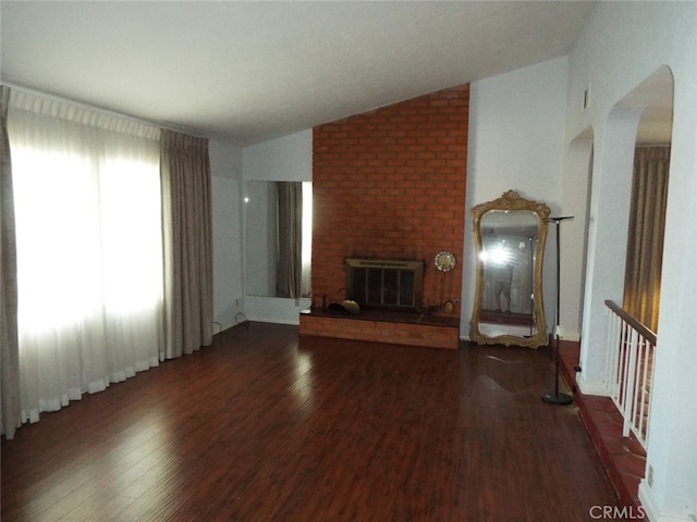 unfurnished living room featuring a fireplace, dark hardwood / wood-style floors, and lofted ceiling