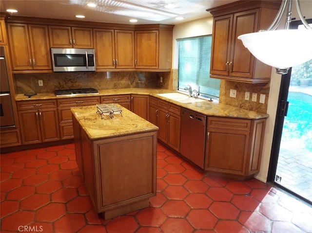 kitchen featuring appliances with stainless steel finishes, a kitchen island, a wealth of natural light, and sink