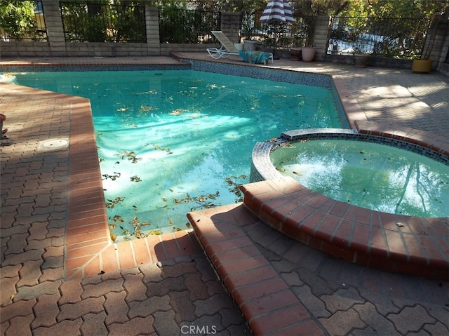 view of swimming pool featuring an in ground hot tub