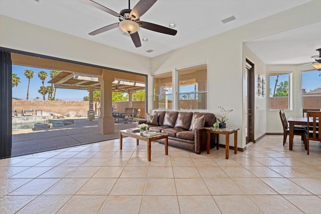 tiled living room with ceiling fan and a healthy amount of sunlight