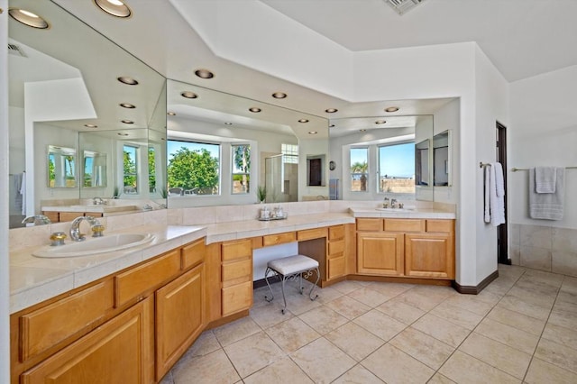 bathroom featuring tile patterned flooring, vanity, and walk in shower