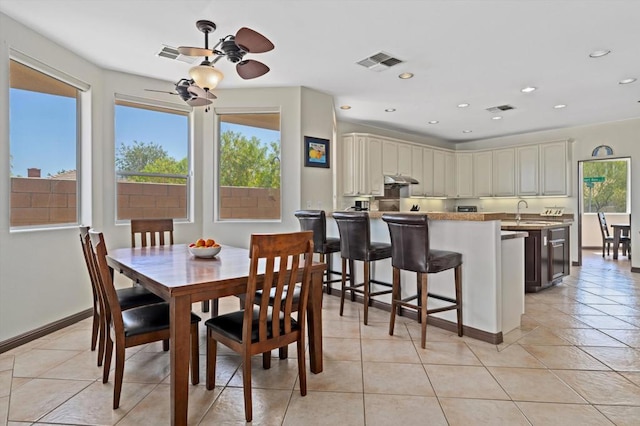 dining area with ceiling fan, light tile patterned floors, and sink