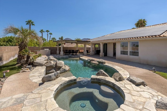 view of pool with ceiling fan, an in ground hot tub, and a patio